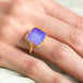 Gold ring with a purple boulder opal stone on a hand