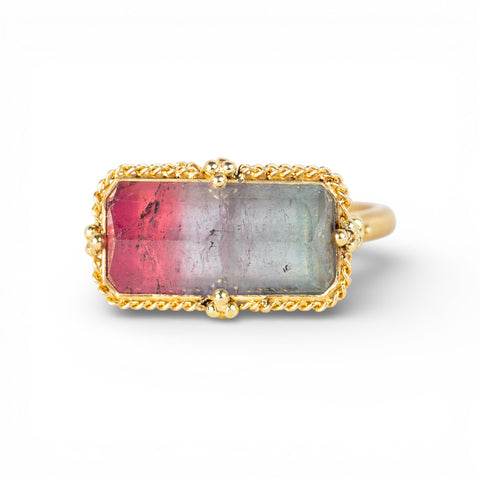 Gold ring with a rectangular watermelon tourmaline gemstone on a white background