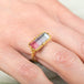 Gold ring with a watermelon tourmaline gemstone on a person's finger