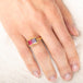 Gold ring with a watermelon tourmaline gemstones on a hand against a white background