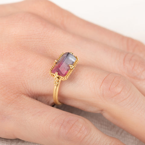 Gold ring with a watermelon tourmaline gemstone on a hand