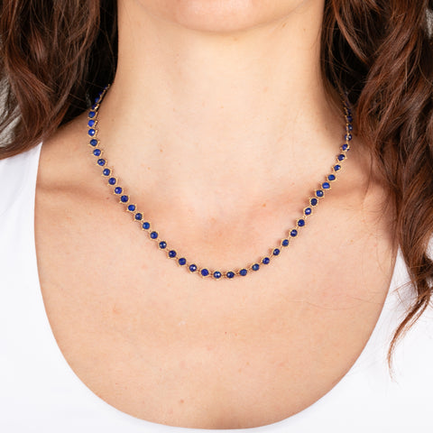 Gold chain necklace with lapis gemstones on a person