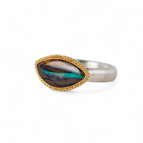 Yowah nut opal ring with a gold setting and silver band on a white background