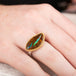 Ring with an opalized wood stone, gold setting and silver band on a hand