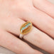 Ring with an opal stone, gold setting and silver band on a hand