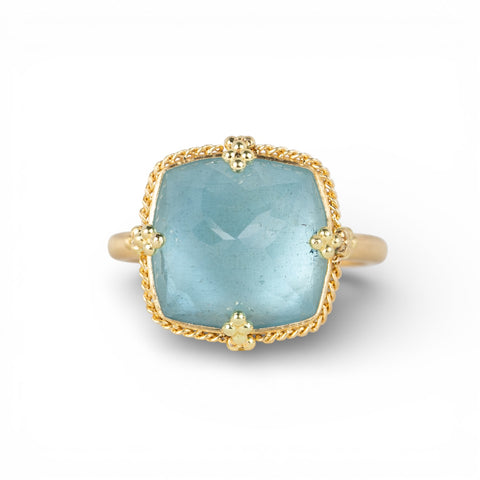 Gold ring with an aquamarine gemstone on a white background