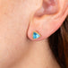 Blue topaz and gold stud earrings on model