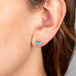 Blue topaz and gold stud earrings on model