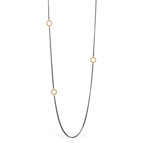 Oxidized silver necklace with 18k gold hoops on white background