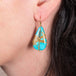 Draped turquoise earrings on a model with blue diamond