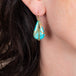 Draped turquoise earrings on a model