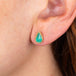 Emerald and gold teardrop stud earrings on model