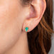 Emerald and gold teardrop stud earrings on model