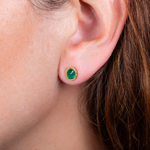 Oval emerald stud earrings on a model