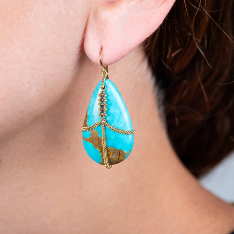 Large draped turquoise earring on a model