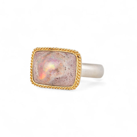 Handcrafed ring featuring a mexican opal gemstone in an 18k gold setting with a sterling silver band