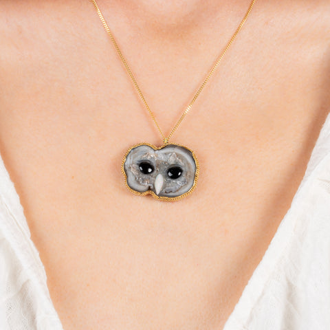 Sand rose owl necklace on a model.