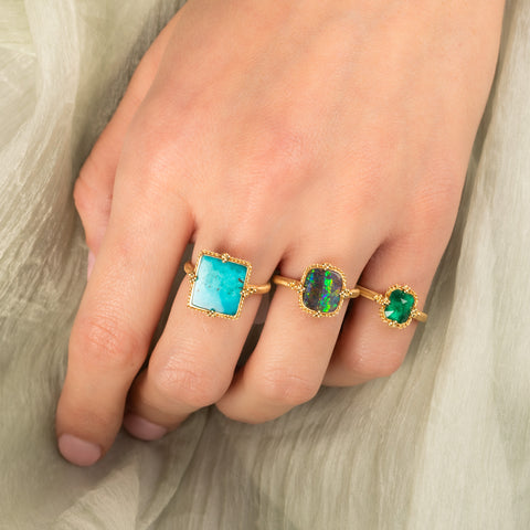 Turquoise portrait ring paired with boulder opal and emerald rings