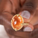 Spessartite ring held in hand