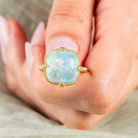 Square ethiopian opal ring held in hand