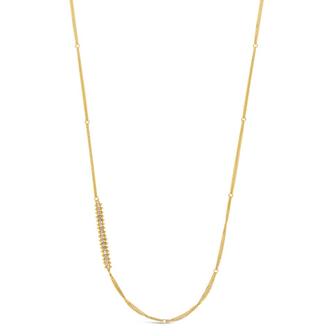 This long gold chain features a row of woven silver diamonds beads stationed off-center. The necklace is finished with a lobster clasp