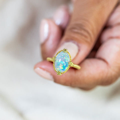 Elevate your style with this Ethiopian Opal ring in 18K yellow gold, featuring a stunning display of colorful confetti. Handmade gold frame showcases braided detail and granulation. Handmade in New York.