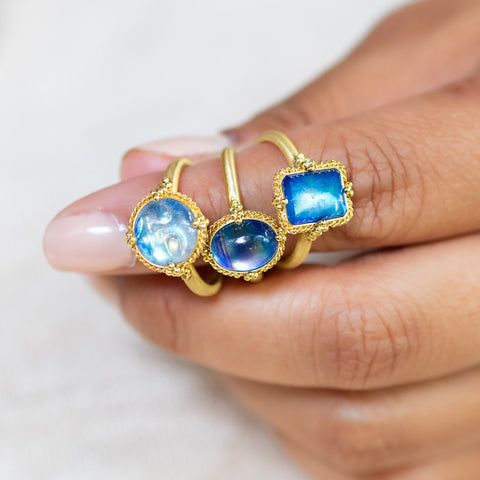 A cluster of three moonstone rings on a model.