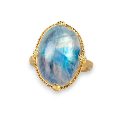 Moonstone ring in 18K yellow gold, featuring a swirling, blue iridescence. Set in a hand-crafted gold setting with braided gold and granulated prongs.