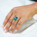 A model wears an 18k yellow gold ring with a large oval labradorite stone in the center