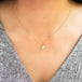 A model wears this pear-shaped Diamond pendant on an 18K yellow gold chain. Handmade gold bezel features braided detail.