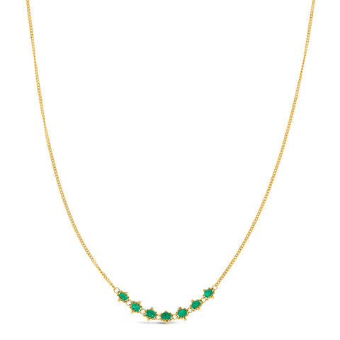 This delicate 18k yellow gold necklace features a row of seven woven emerald beads in the center. The necklace is finished with a lobster clasp closure