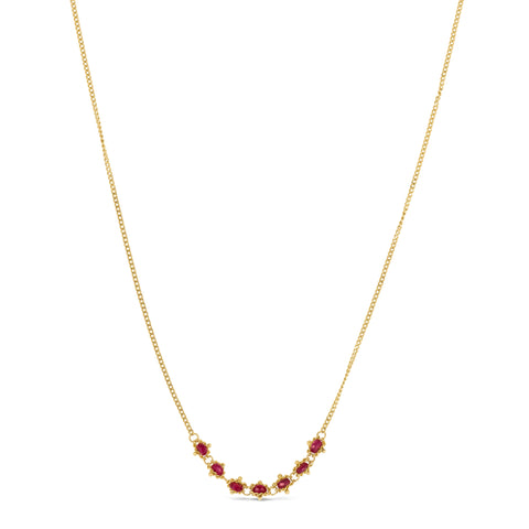 This delicate 18k yellow gold necklace features a row of seven woven ruby beads in the center. The necklace is finished with a lobster clasp closure
