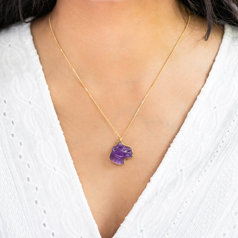 A model wears this Amethyst panther pendant on an 18K yellow gold chain. Handmade gold bezel features braided detail. Handmade in New York.