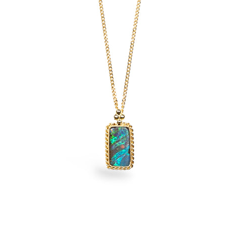 A rectangular Boulder Opal pendant is set in 18k yellow gold bezel, suspended from an 18K yellow gold chain. Opal displays mesmerizing neon greens and blues, set in a unique one-of-a-kind design with braided detail.
