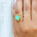 A model wears a round Ethiopian opal ring