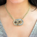 Sand rose owl carved pendant on an 18k yellow gold woven diamond chain close up
