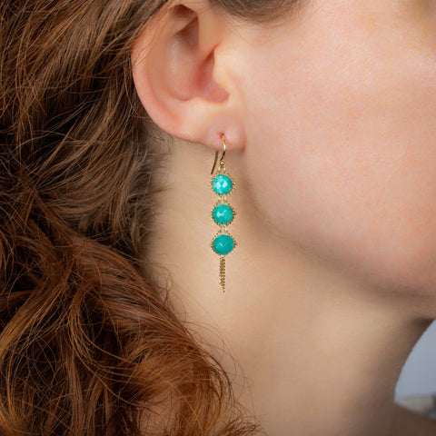 A close-up of an amazonite trio earring suspended in 18k yellow gold chain.