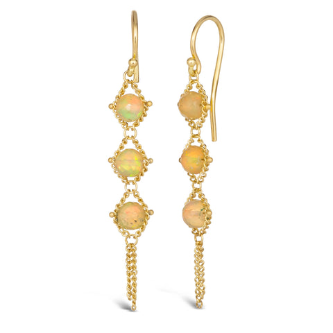 A pair of long 18k yellow gold earrings are crafted with opal beads suspended in delicate chain. The earrings are fastened with French hook closures.