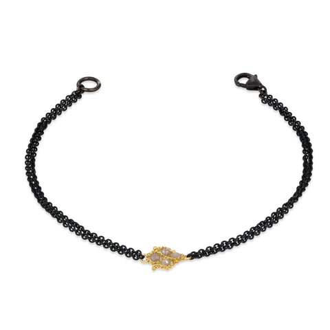 This delicate bracelet features double oxidized sterling silver chains with an 18k yellow gold and silver diamond lattice in the center.