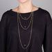 A model wears three delicate chain necklaces with black diamond beads dotted throughout. The necklace is featured in three lengths of 16", 24" and 36"