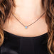 A small irregular oval shaped Australian opal is set in 18k yellow gold on an oxidized sterling silver chain.
