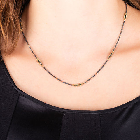 Black diamond and 18k yellow gold bars are stationed throughout an oxidized sterling silver chain.