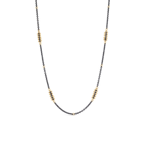 Stations of black diamonds set in 18k gold are dotted throughout a short oxidized sterling silver chain.