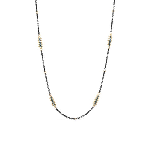 An oxidized sterling silver chain is studded with 18k yellow gold wrapped blue diamonds.
