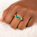 A model wears a large rectangular opal ring featuring a chain wrapped bezel and four granulated prongs on a thin band.