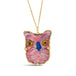 A light pink rhodochrosite is carved into an owl with gold and black eyes and a blue beak. The stone is wrapped in an 18k yellow gold braided bezel with four beaded prongs around the edge and hangs from a delicate chain.
