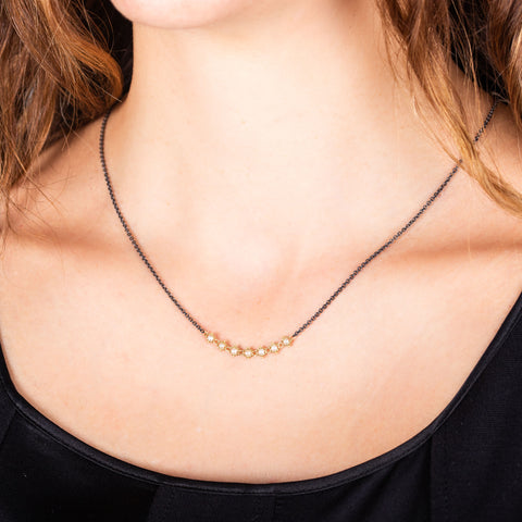 A row of 18k yellow gold chain wrapped pearls are set in the center of an oxidized sterling silver chain.