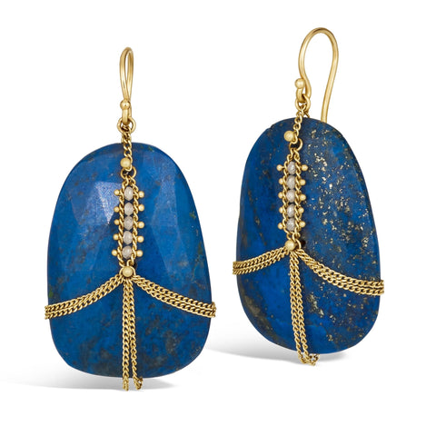 A pair of large lapis stone earrings are wrapped in delicate chain scattered with silver diamonds. The earrings hang on french hook closures.