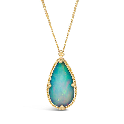 A teardrop shaped Ethiopian opal pendant is set in an 18k yellow gold chain wrapped bezel with four beaded prongs. The pendant hangs on a delicate chain.