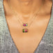 A model wears two rectangular watermelon tourmaline pendant necklaces set in 18k yellow gold.